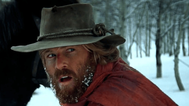 Jeremiah Johnson (Robert Redford) looks away from his horse in the snow in Jeremiah Johnson