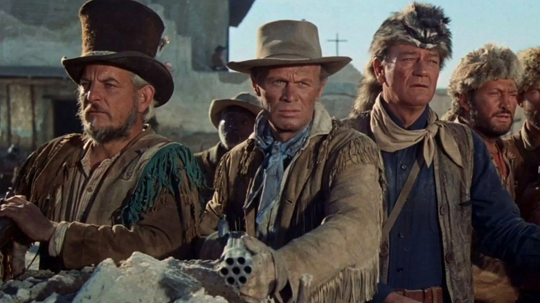 Davy Crockett (John Wayne) and Jim Bowie (Richard Widmark) stand in a line of men in The Alamo (1960)