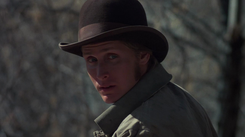 Billy the Kid (Emilio Estevez) looks back wearing a bowler hat in Young Guns