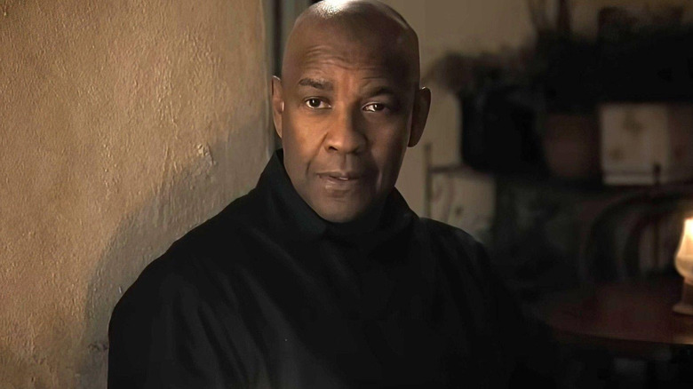 Denzel Washington as Robert McCall sitting at a table with his tea in The Equalizer 2
