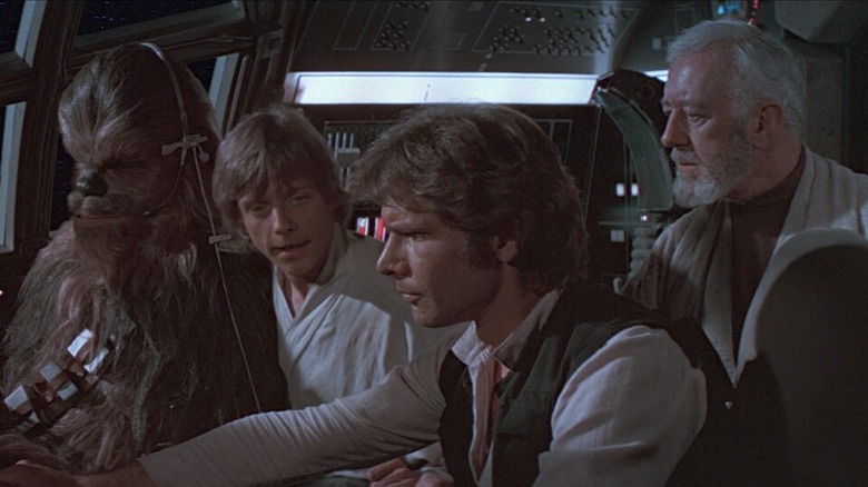 Chewbacca, Luke, Han Solo, and Obi-Wan Kenobi in the cockpit of the Millennium Falcon in Star Wars: A New Hope