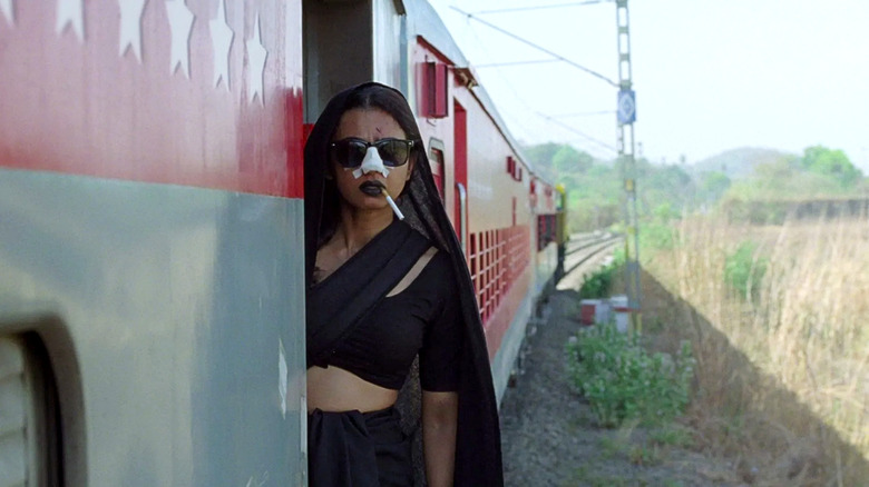 Uma (Radhika Apte) hangs out of a train door with a bandaged nose and a cigarette in her mouth in Sister Midnight