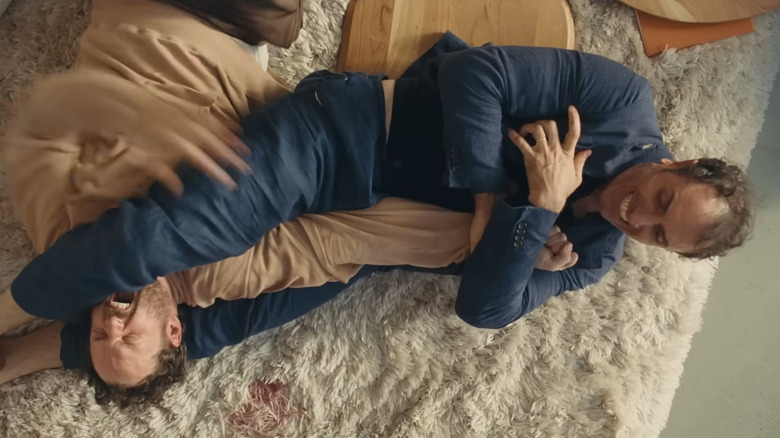 Paul and Carey fighting on the carpet in Splitsville