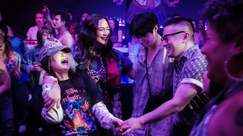 Kelly Marie Tran as Angela, Lily Gladstone as Lee, Han Gi-chan as Min, and Bowen Yang as Chris all dancing in a club in The Wedding Banquet