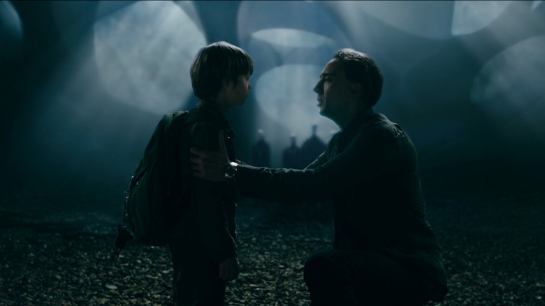 Nicolas Cage kneels with son