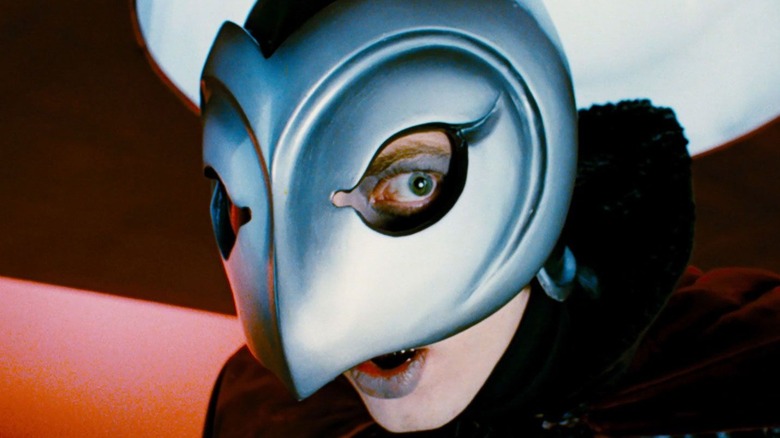 man wearing a metal mask and black cape