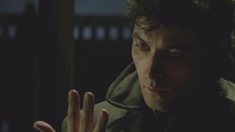 Rufus Sewell stares at his hand.