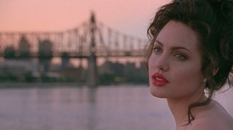 Gia with hair up in red lipstick looking out over the river in Gia