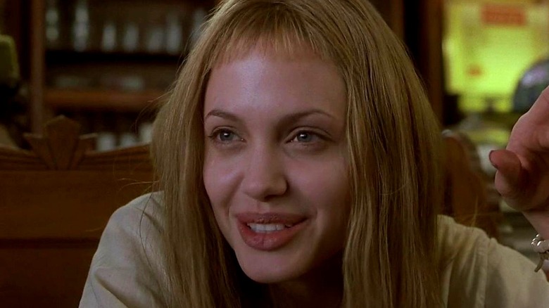 Blonde Angelina Jolie smiling and pointing in Girl, Interrupted