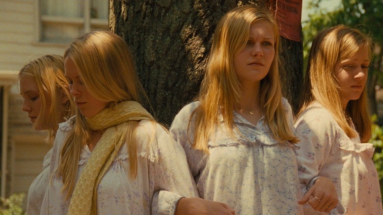 The Lisbon sisters linking arms around a tree in The Virgin Suicides