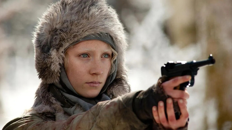 Hanna (Saoirse Ronan) aims a pistol while wearing winter clothing in Hanna