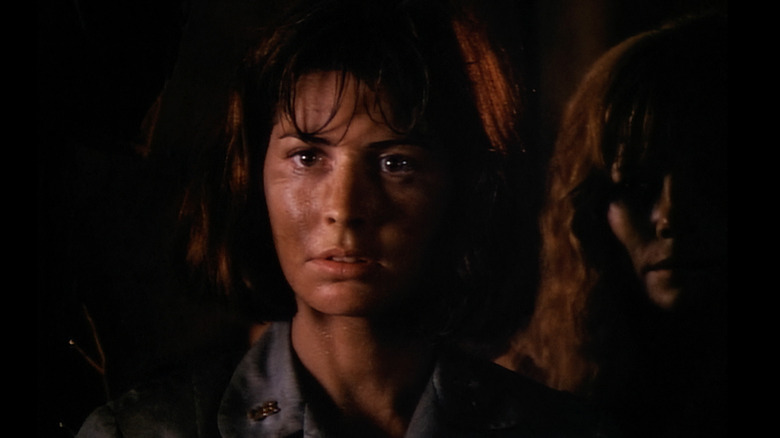 Dana Delany with dark background and dirty face as Colleen in China Beach