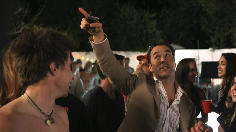 Jeremy Piven as Ari Gold holding a cellphone and pointing up at something off camera in Entourage