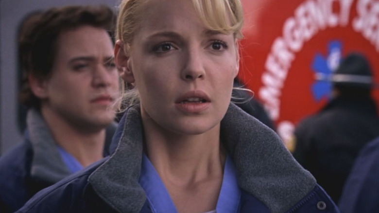 Katherine Heigl standing in blue scrubs and a jacket as Izzie Stevens in Grey's Anatomy