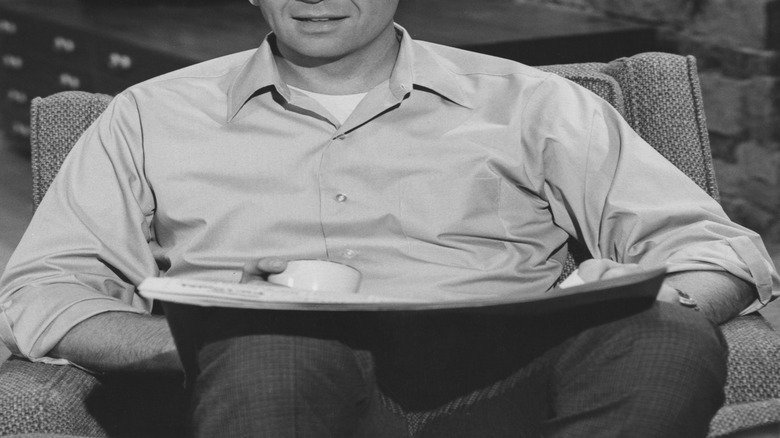Mike Brady (Robert Reed) sitting in a chair on The Brady Bunch