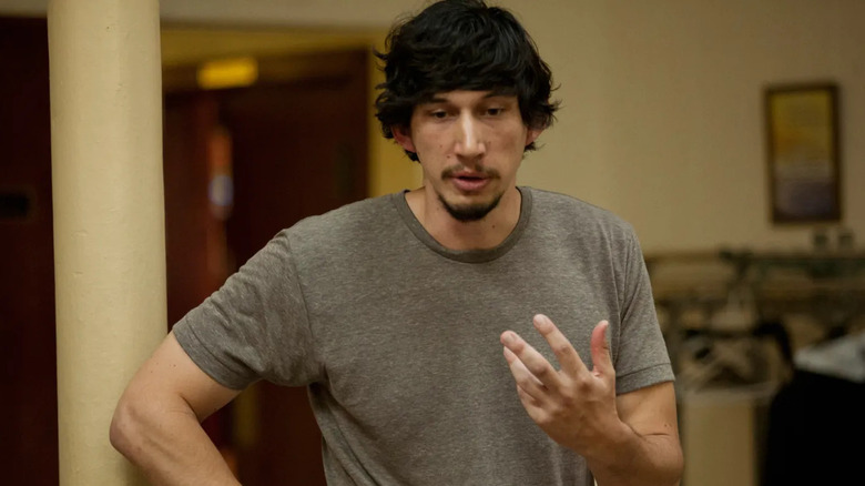 Adam Driver standing and talking as Adam in Girls