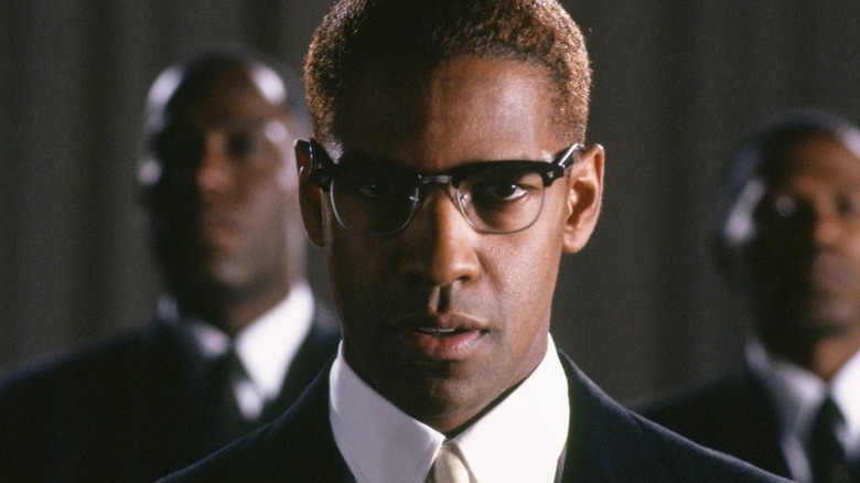 Denzel Washington as Malcolm X in glasses staring ahead in Malcolm X