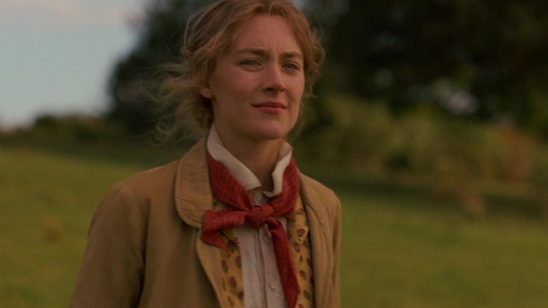 Saoirse Ronan as Jo March standing in an open field in Little Women