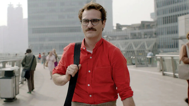 Joaquin Phoenix as Theodore Twombly, standing in the middle of a street in Her.