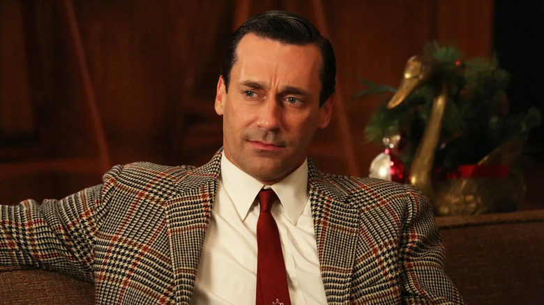 Jon Hamm as Don Draper, sitting on a couch in Mad Men.