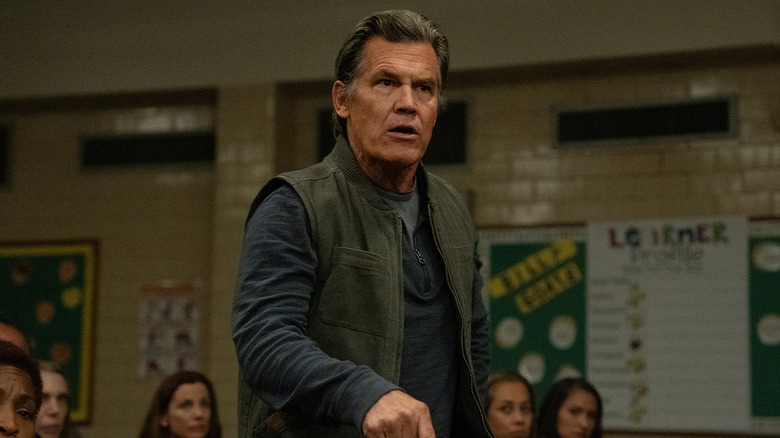 Josh Brolin as Archer Graff, standing up at a school meeting in Weapons.
