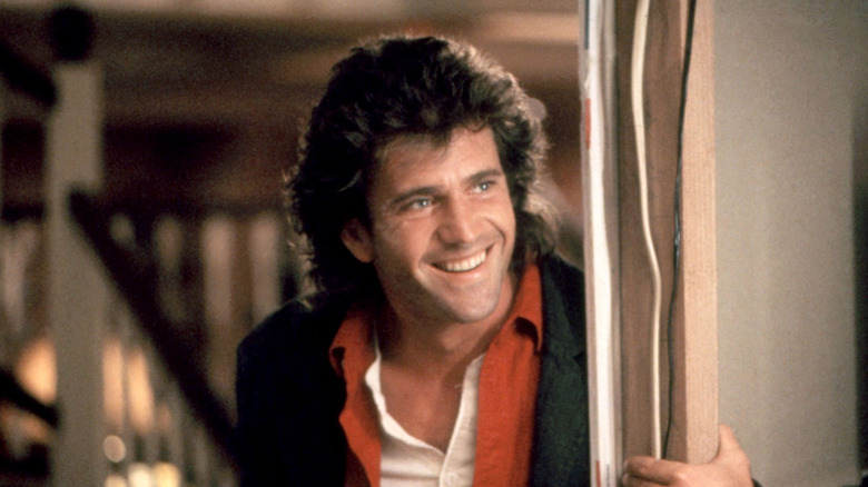 Mel Gibson as Martin Riggs, smiling in a doorway in Lethal Weapon.