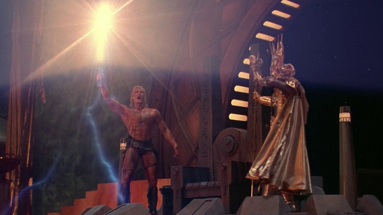 Dolph Lundgren's He-Man raises his sword in front of gold-armored Skeletor in Masters of the Universe