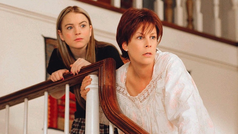 Lindsay Lohan as Anna and Jamie Lee Curtis as Tess looking shocked and nervous leaning over staircase handrailing in Freaky Friday