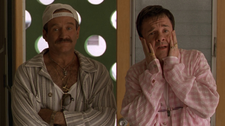 Robin Williams as Armand Goldman with his arms crossed standing next to Nathan Lane as Albert Goldman holding his face in his hands looking dismayed in The Birdcage