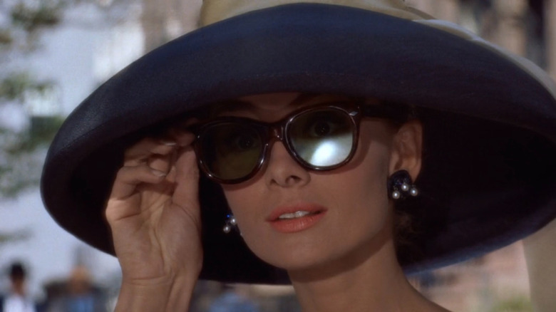 Holly Golightly (Audrey Hepburn) touching sunglasses in Breakfast at Tiffany's