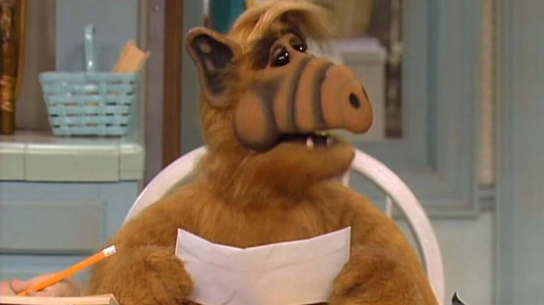 ALF holds a letter at the dining room table in ALF