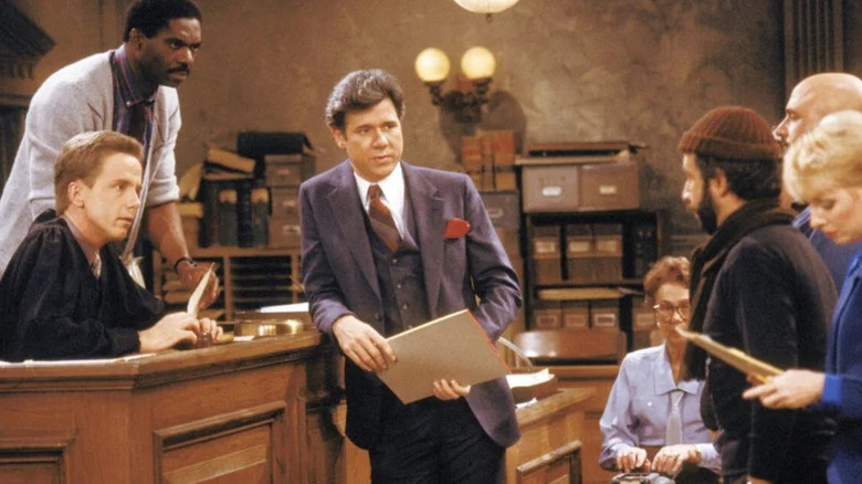Charles Robinson, Harry Anderson, and John Larroquette as Mac Robinson, Judge Harry Stone, and Dan Fielding looking on at a defendant in Night Court