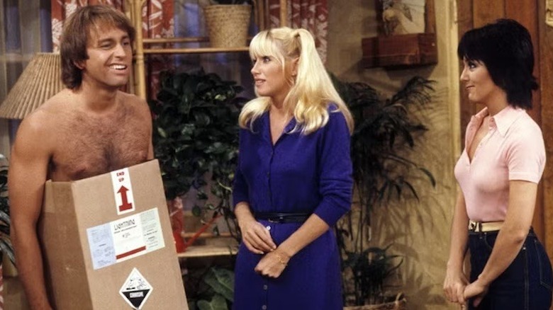 Jack Ritter as Jack Tripper wears a cardboard box as Joyce DeWitt and Suzanne Somers's Chrissy Snow and Janet Wood try not to judge in Three's Company