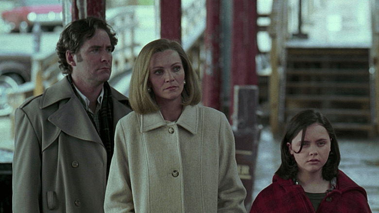 Ben Hood (Kevin Kline), Elena Hood (Joan Allen), and Wendy Hood (Christina Ricci) stand at a train station in The Ice Storm