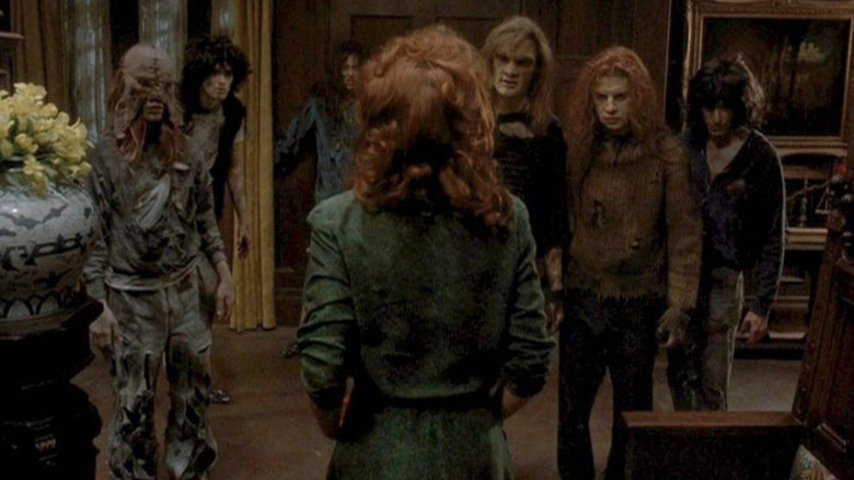 A woman looks at threatening people from under the stairs in The People Under the Stairs