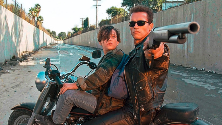 The Terminator (Arnold Schwarzenegger) points a shotgun to protect John Connor (Edward Furlong) in Terminator 2 Judgment Day