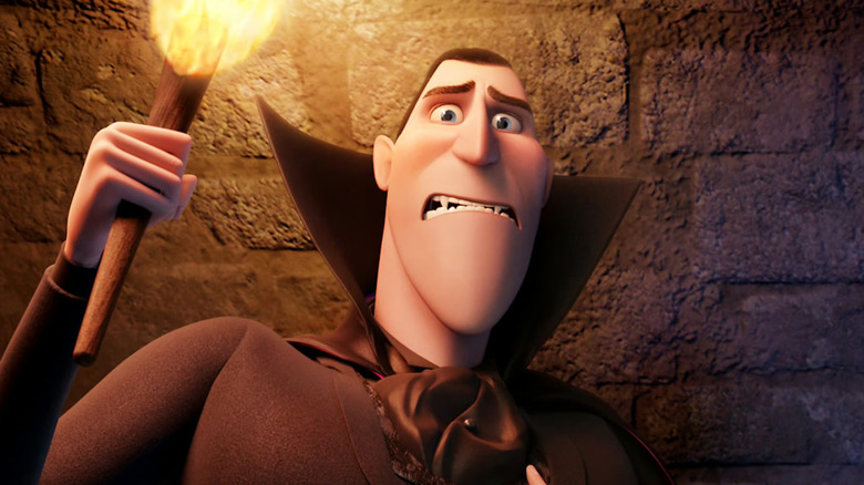 Dracula cowering while holding a torch in Hotel Translyvania