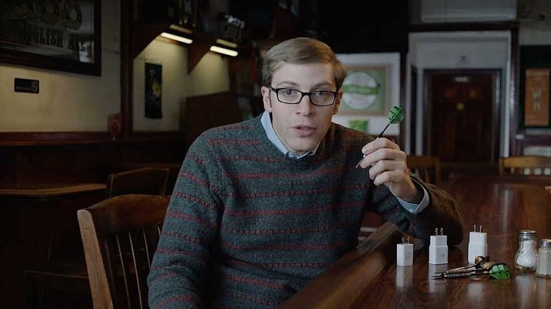 Joe Pera speaks to the camera while holding a dart in a bar in Joe Pera Talks with You