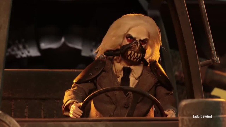 An action figure of Immortan Joe in a suit driving a truck in Robot Chicken