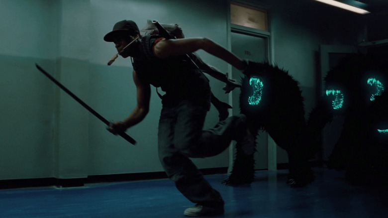 John Boyega as Moses in Attack The Block, outrunning the alien creatures through an estate hallway with a sword.