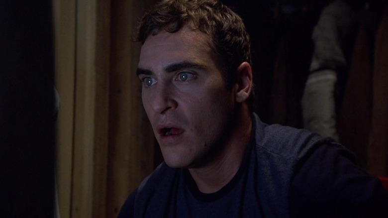 Joaquin Phoenix as Merrill Hess in Signs, seen looking at a small television, aghast at the on-screen image.