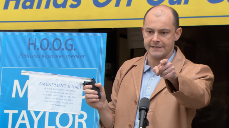 Rob Corddry as Moses Taylor, wielding a gun with the second amendment hidden inside on Arrested Development