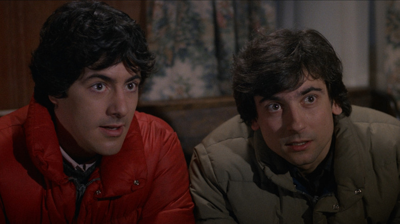 David Naughton as David Kessler and Griffin Dunne as Jack Goodman in An American Werewolf in London, sitting next to each other and looking at something out of frame.