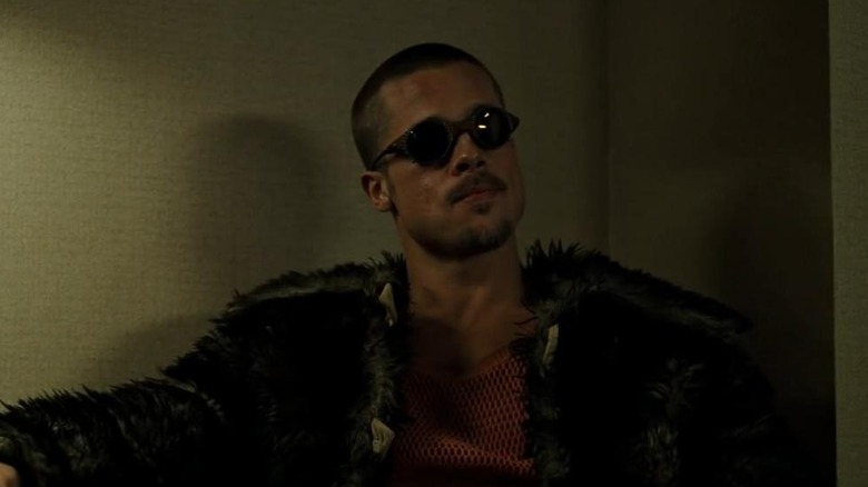 Brad Pitt as Tyler Durden in Fight Club, wearing sunglasses indoors and looking past the camera.