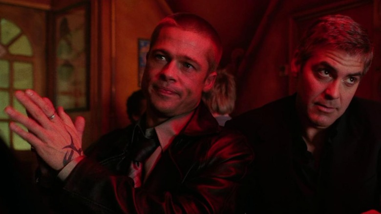 Brad Pitt as Robert Ryan and George Clooney as Danny Ocean, looking different directions out of frame in Ocean's Twelve.