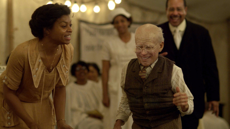 Brad Pitt as Benjamin Button, dancing alongside Taraji P. Henson as Queenie among other people in the background.