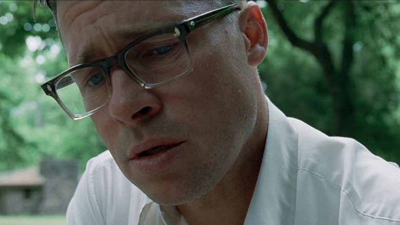Brad Pitt as Mr. O'Brien in The Tree of life, with glasses on and looking down at something past the camera.
