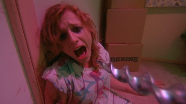 Juliette Cummins as Sheila cowering in horror at a power drill in Slumber Party Massacre II