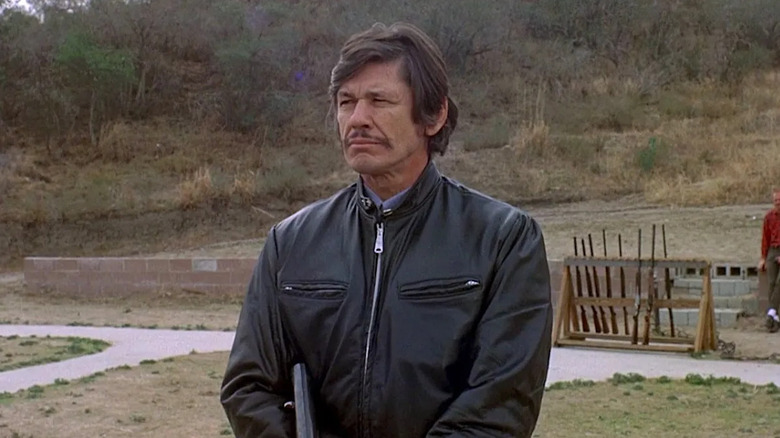 Charles Bronson as Arthur, measuring up the competition in The Mechanic