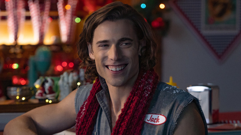Dustin Milligan as Jack Snowman, smiling in a bar in Hot Frosty